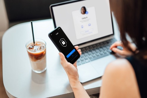 woman looking at secure smart phone and computer