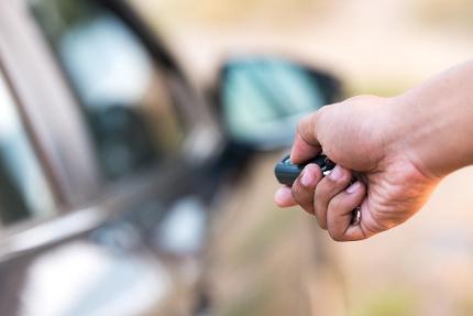 hand pointing key fob at car