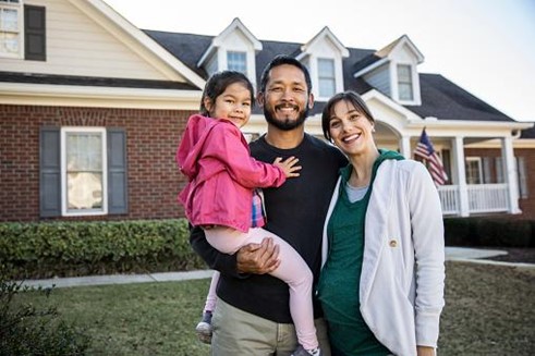 Young family in front of their home