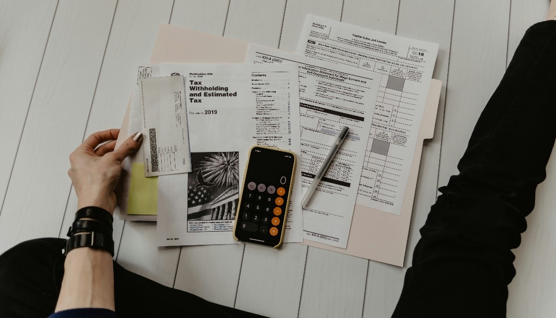 a person sits and sifts through tax forms and documents