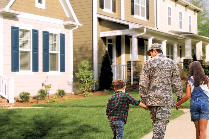 military soldier walking with two children in residential neighborhood