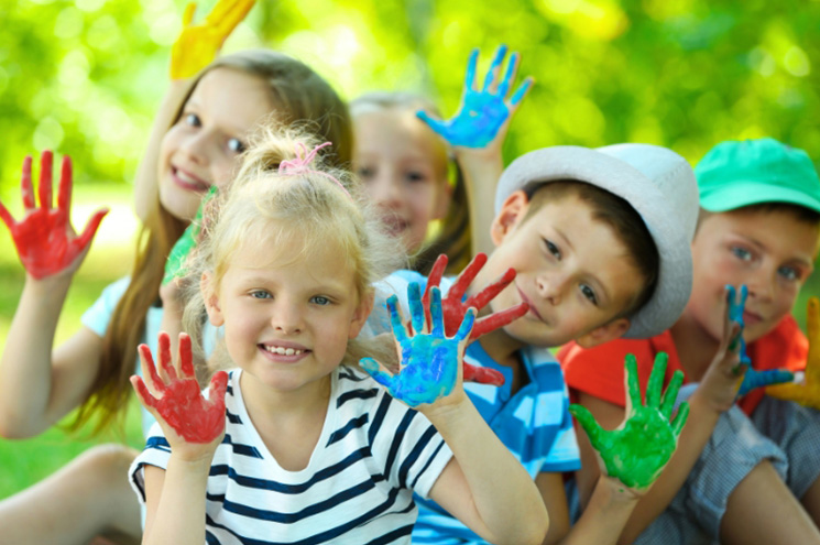 boys and girls showing their hands covered in paint for handprint art