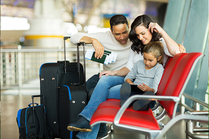 family looking at phone while waiting at the airport