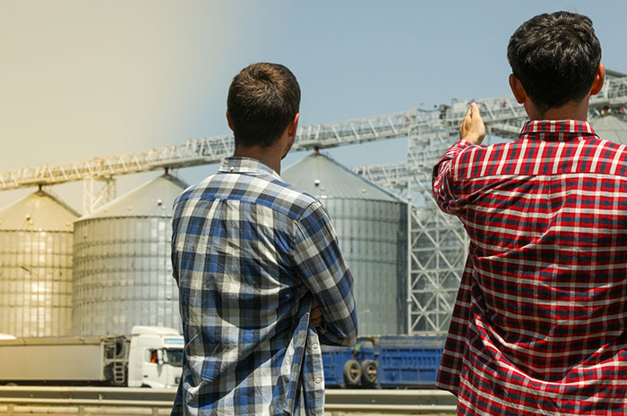 young farmers pointing to grain bins