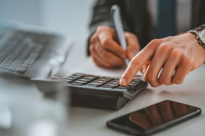 closeup of hands using a calculator such as a small business owner