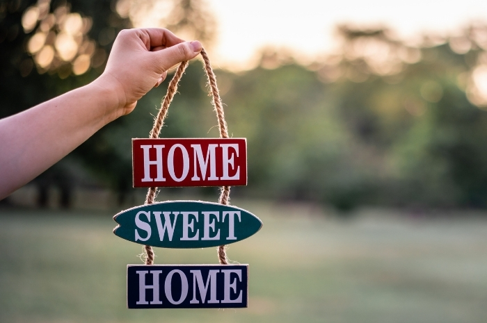 hand holding decorative Home Sweet Home sign