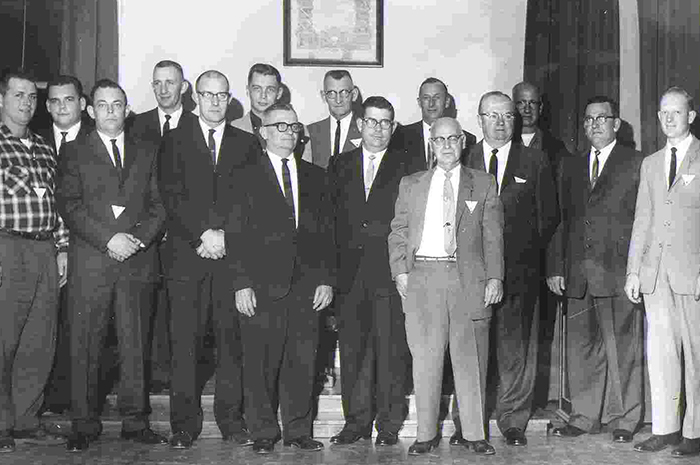 a group of men gather in 1961
