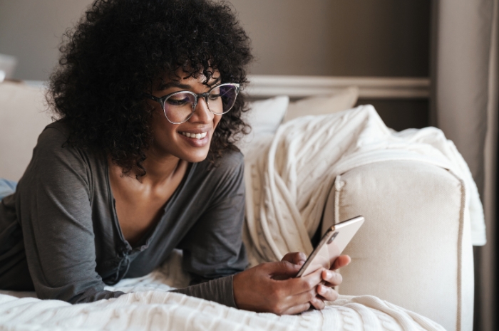 young woman at home looks at her mobile device
